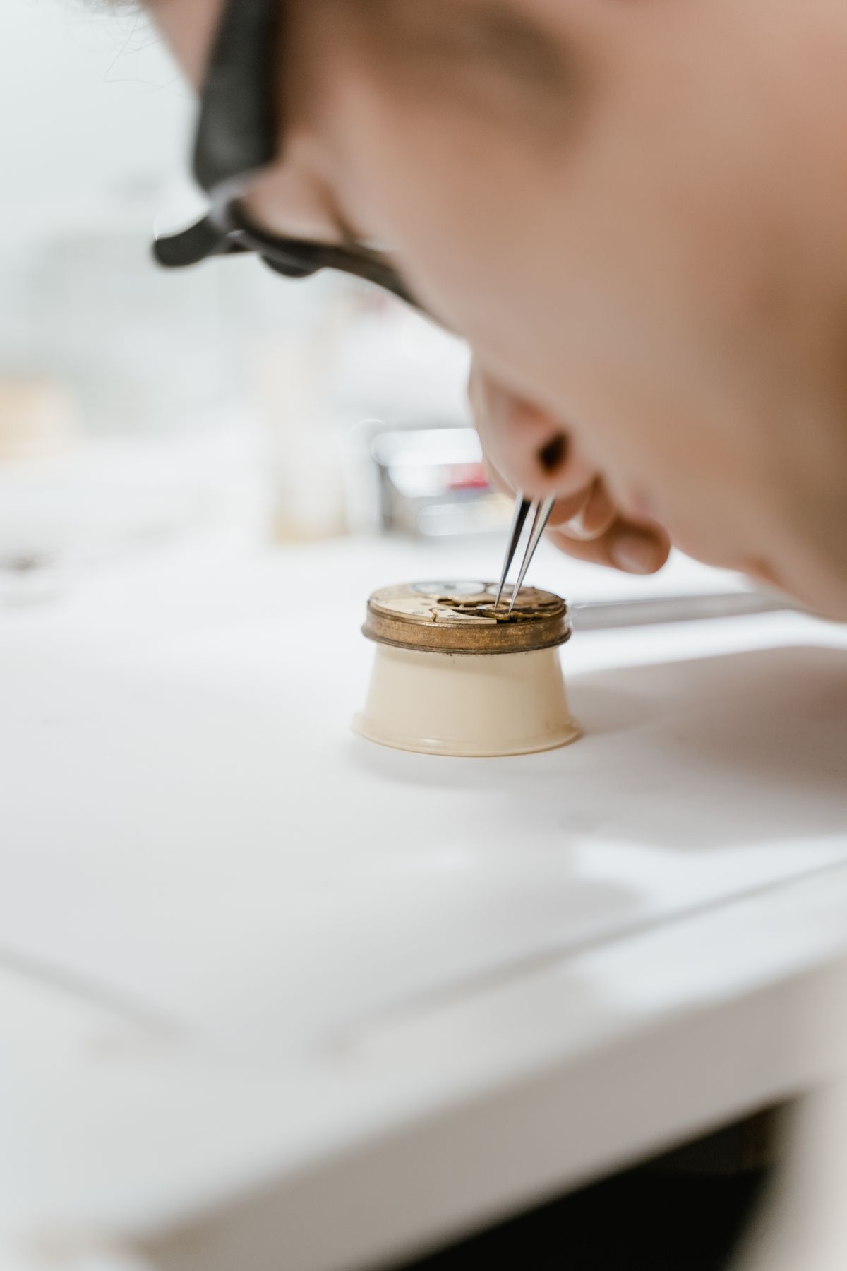 Watchmaker adjusting a watch movement with tweezers at Saltzman's Watches