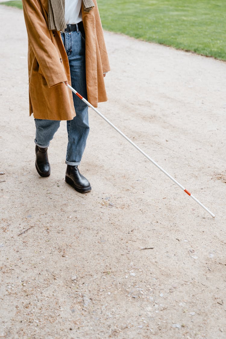 A Person Walking With A Cane