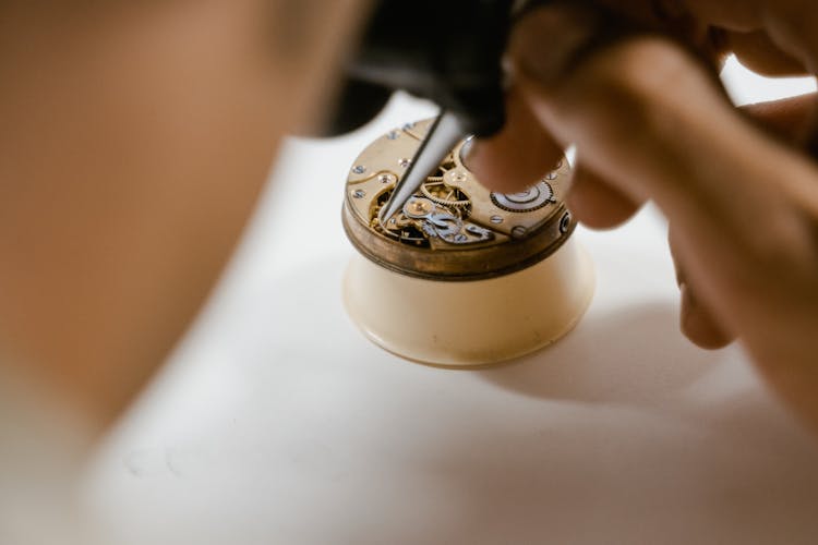 Person Fixing A Vintage Timepiece