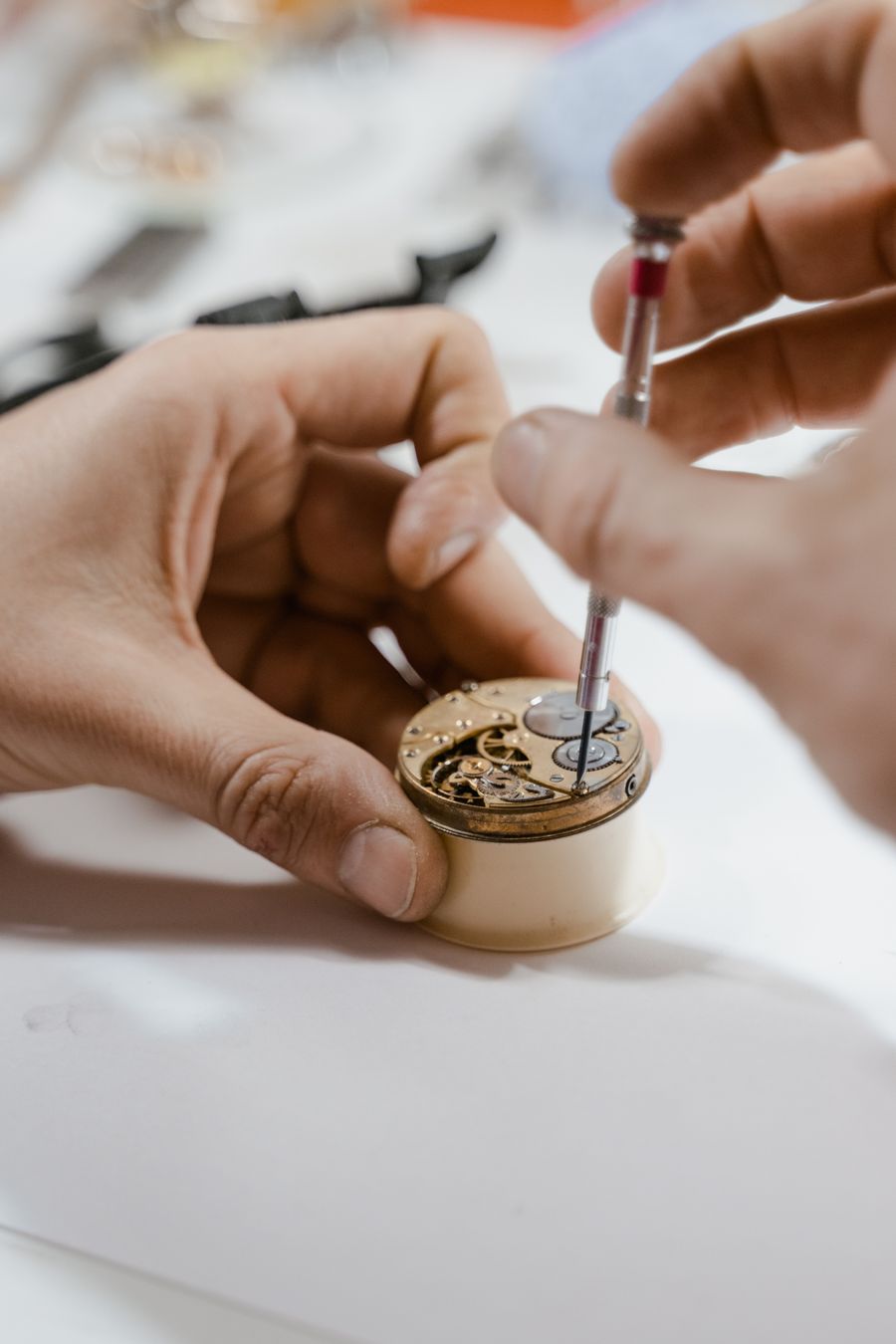 A watchmaker steadying a movement while setting a screw with a precision driver — photo by Tima Miroshnichenko on Pexels