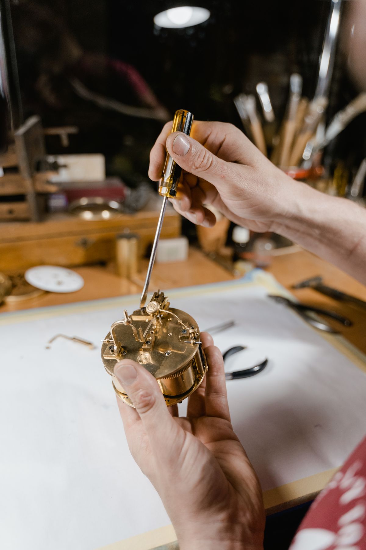 Relojero usando un destornillador para reparar un reloj de tapa atornillada