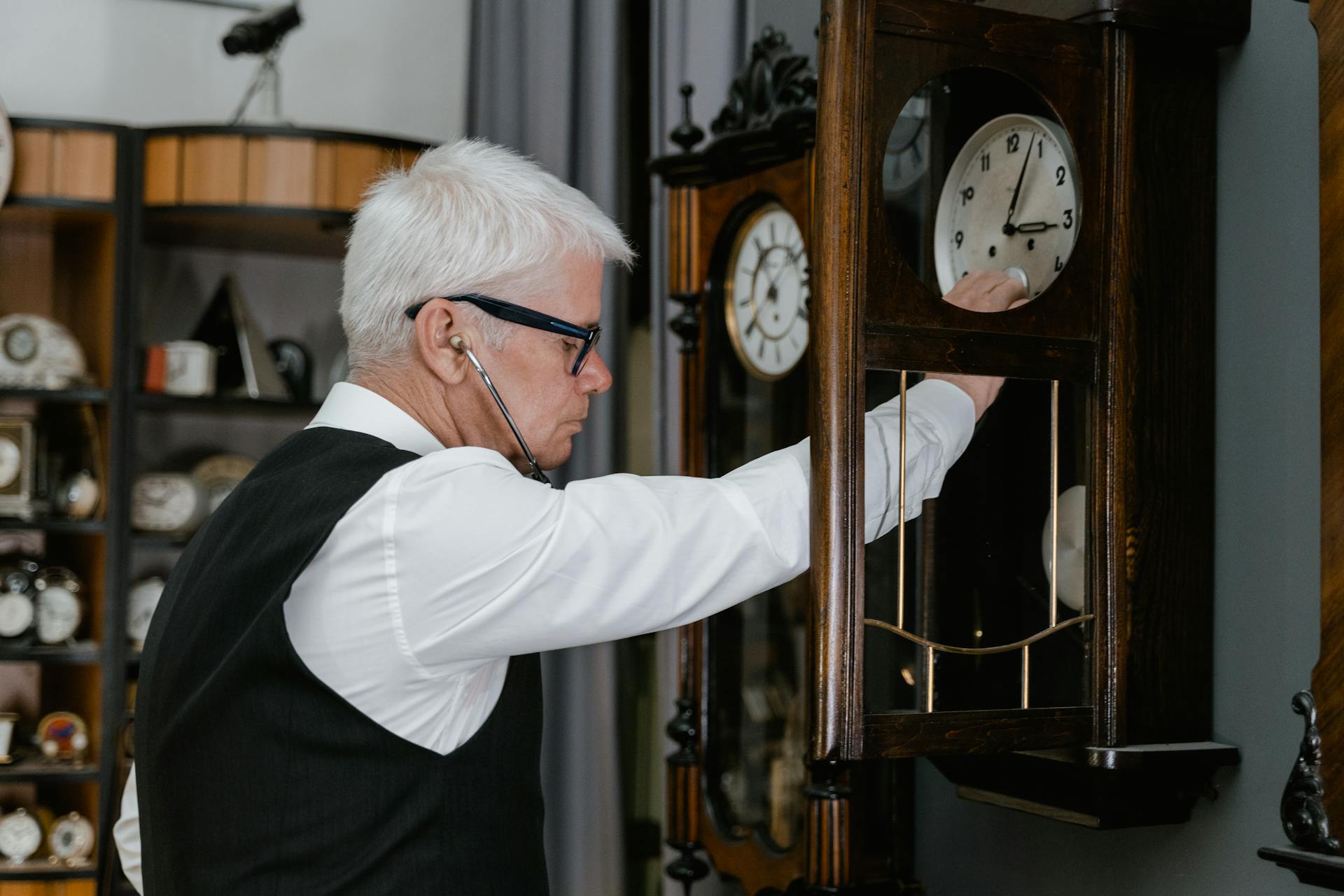 Elegant Elderly Man Wiping Wooden Clock