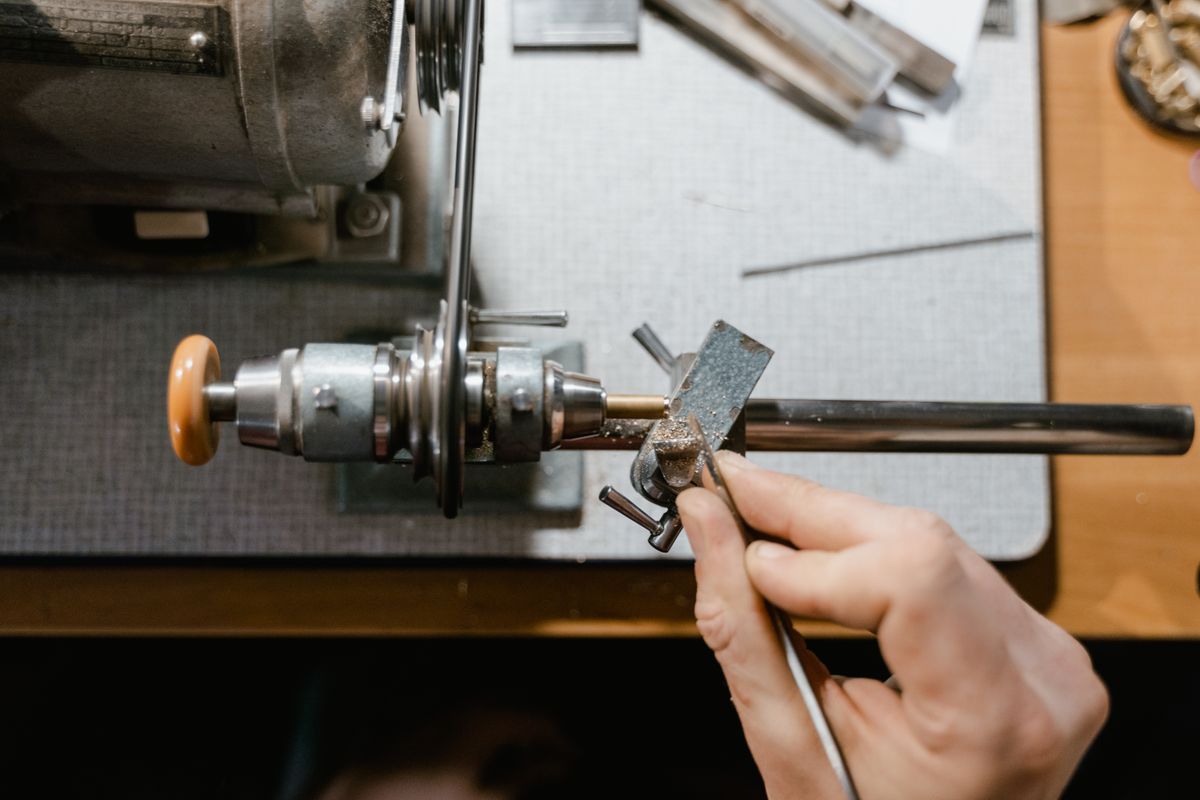 A watchmaker turning a part on a bench lathe — photo by Tima Miroshnichenko on Pexels