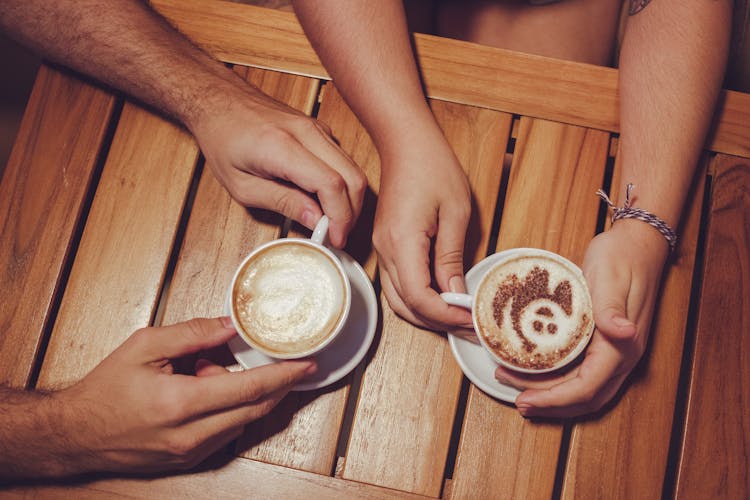 Two People Holding White Cup With Coffee