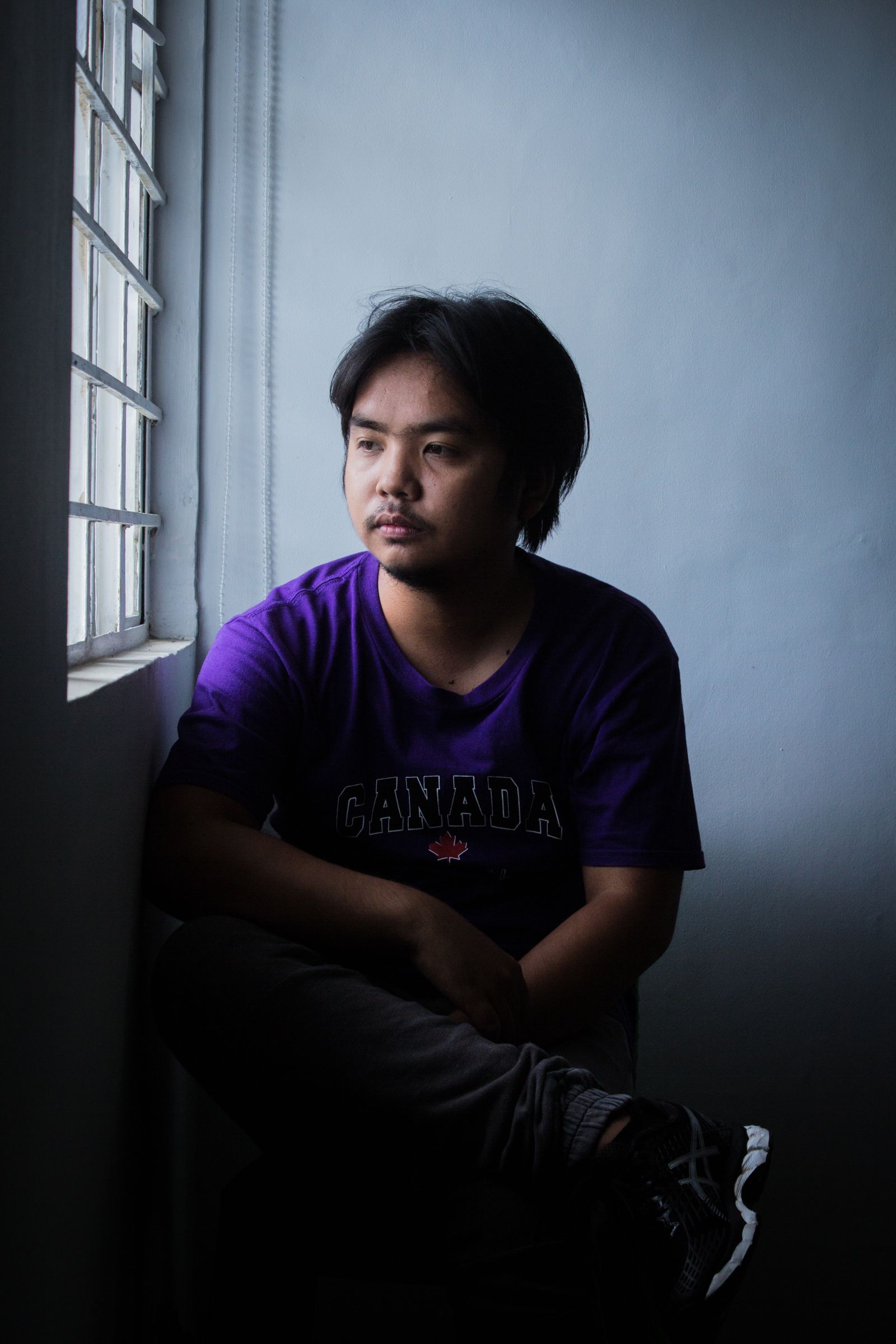 A person sitting quietly beside a window
