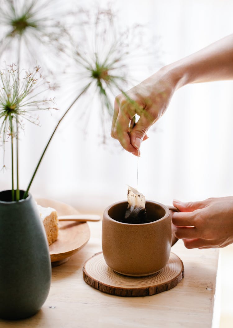 Close-up Of Person Making Tea In Cup