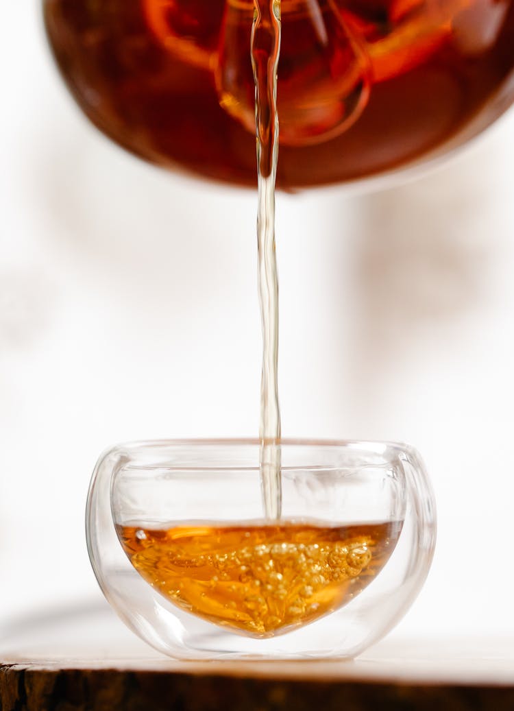 Tea Being Poured Into A Glass Cup