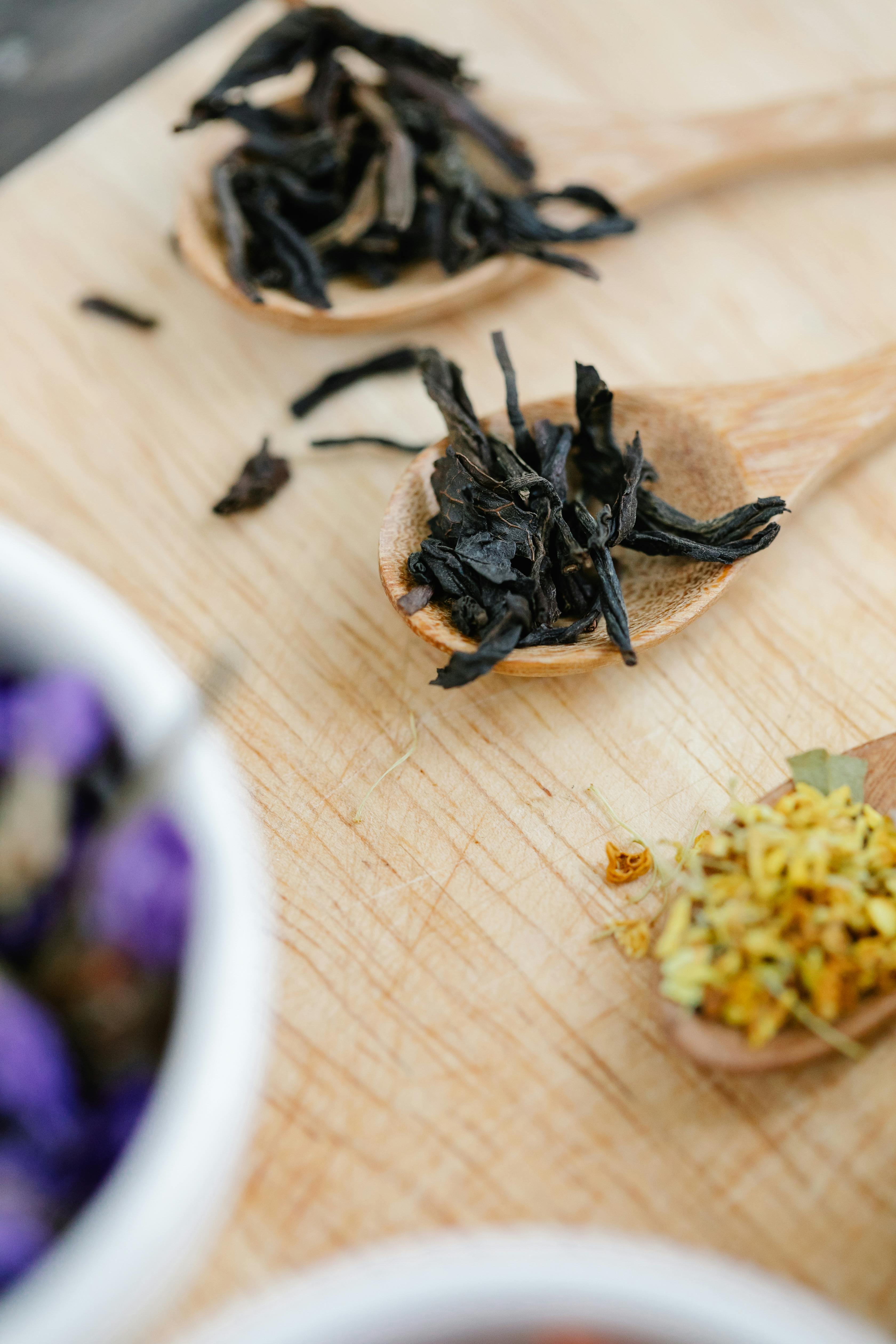 dried tea leaves on wooden spoons