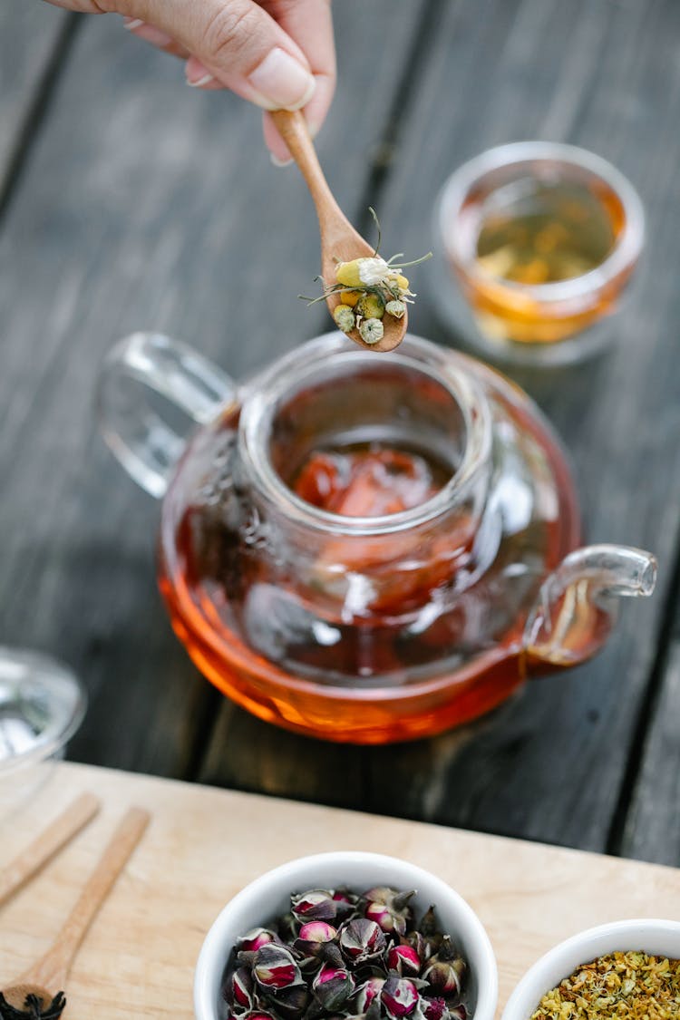 Person Making Tea In Glass Teapot