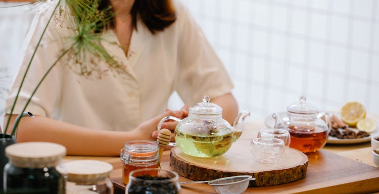 Woman By Table With Honey And Pitchers