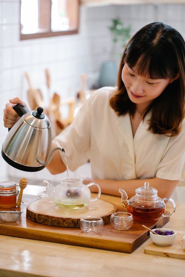 Woman Pouring Boiling Water Into Pot