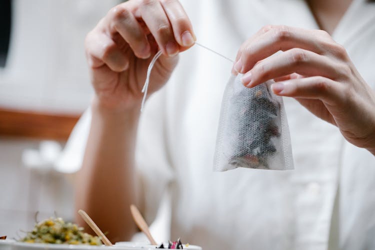 Close-up Of Person Holding Tea In Bag