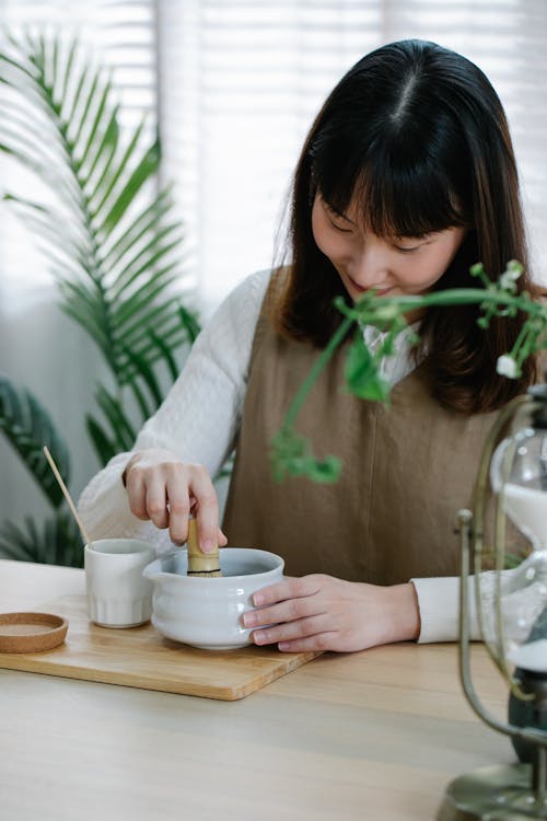 Woman Preparing Traditional Green Tea with Matcha Whisk