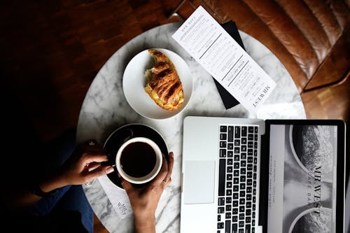Free Macbook Pro and a Cup of Coffee on Table Stock Photo