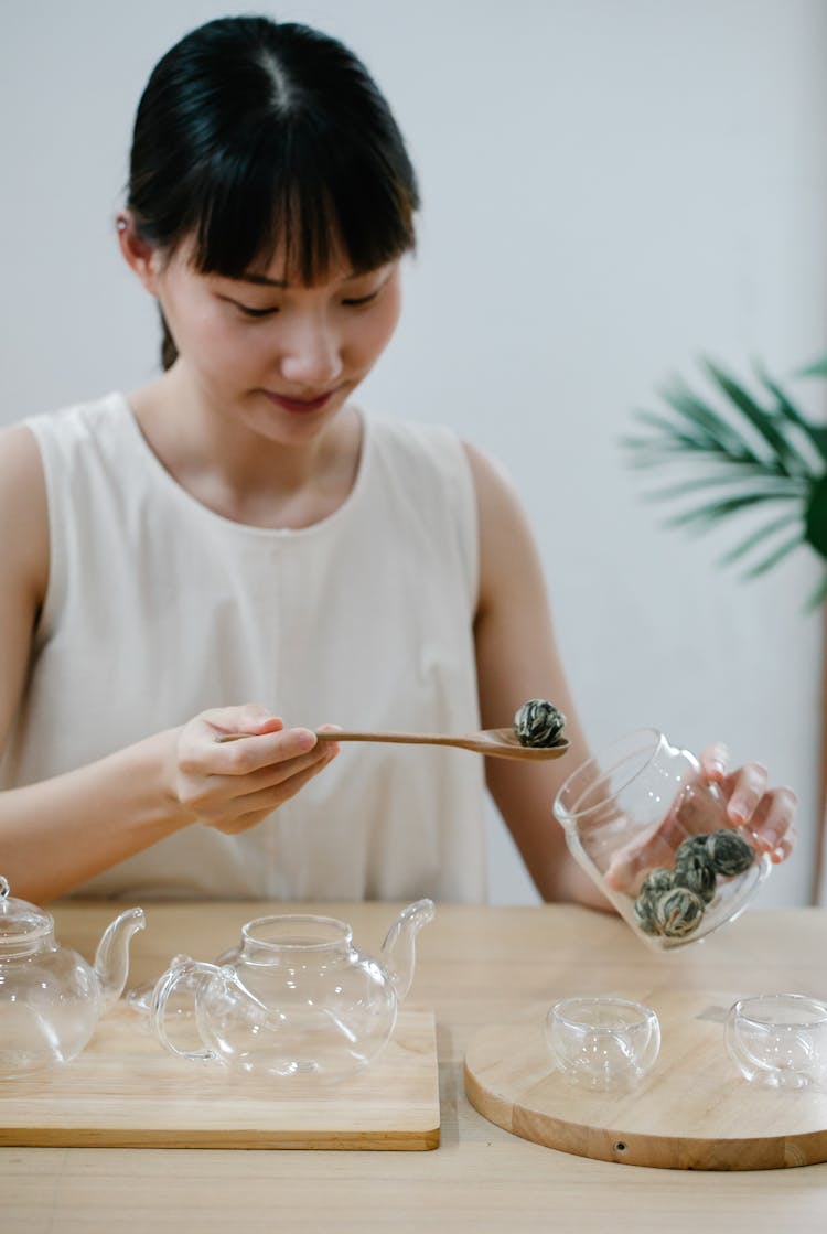 Woman Making Tea In Glass Kitchenware