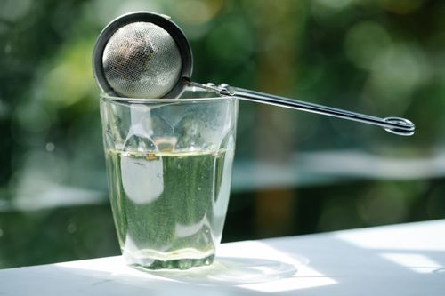 Free Close-up of glass with tea infuser in sunlight, highlighting serenity and refreshment. Stock Photo