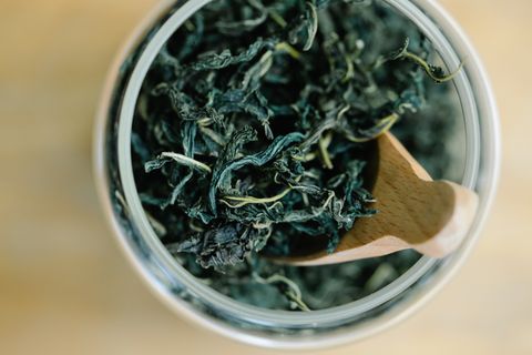 Green tea leaves in a glass jar