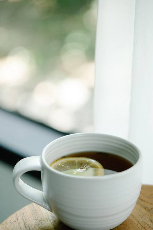 Free A warm cup of tea with a lemon slice by a window, perfect for a relaxing moment. Stock Photo