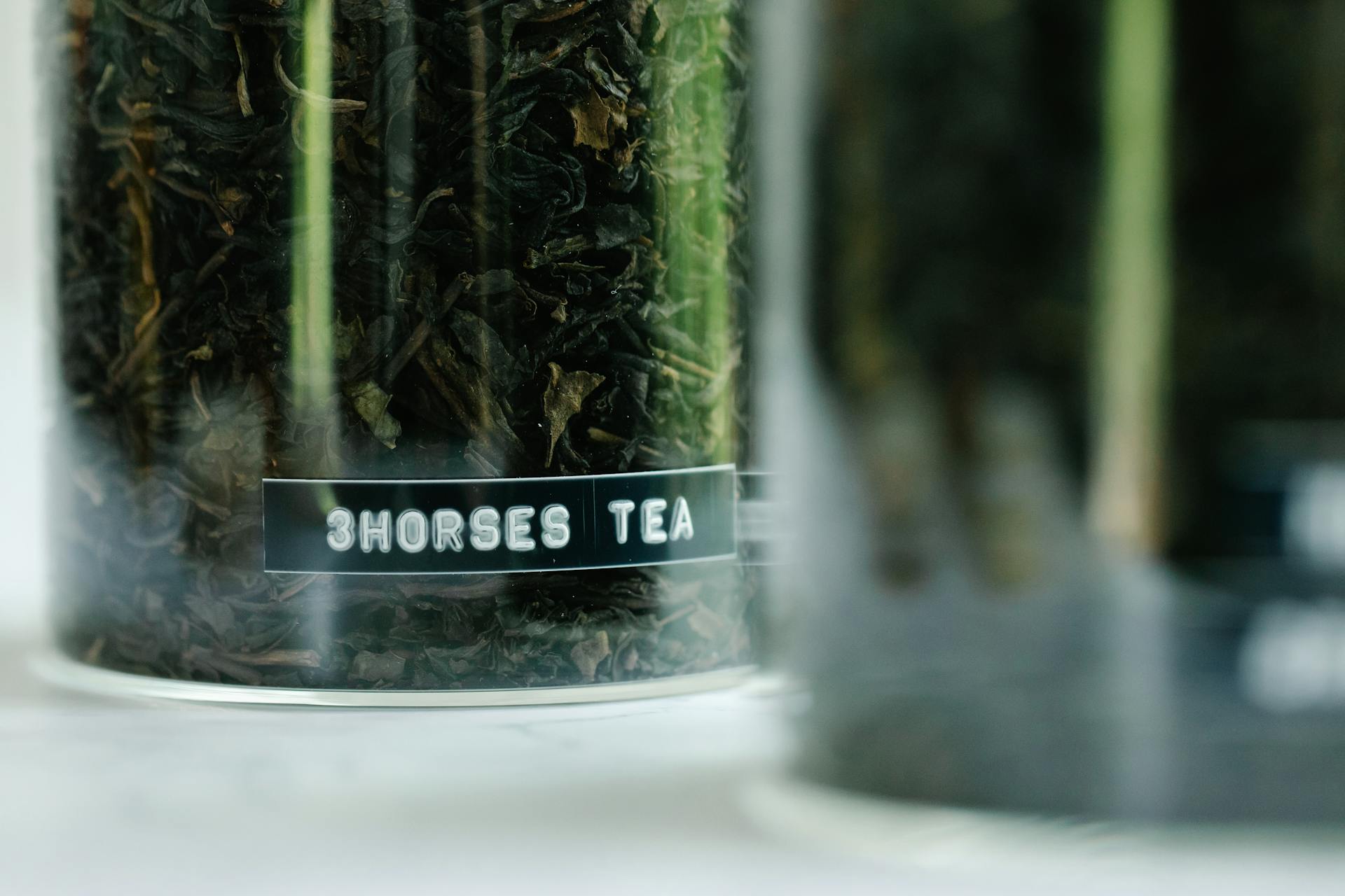 Macro image of dried loose leaf tea labeled '3Horses Tea', perfect for tea lovers.