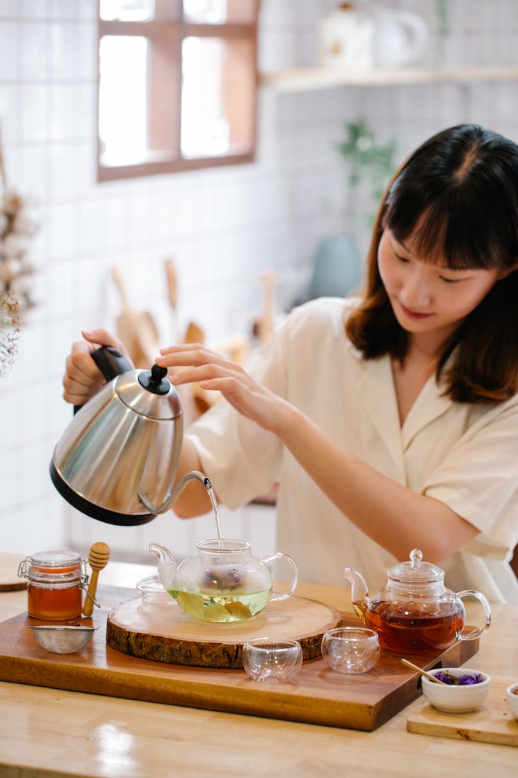 Woman Pouring Water To Pitcher