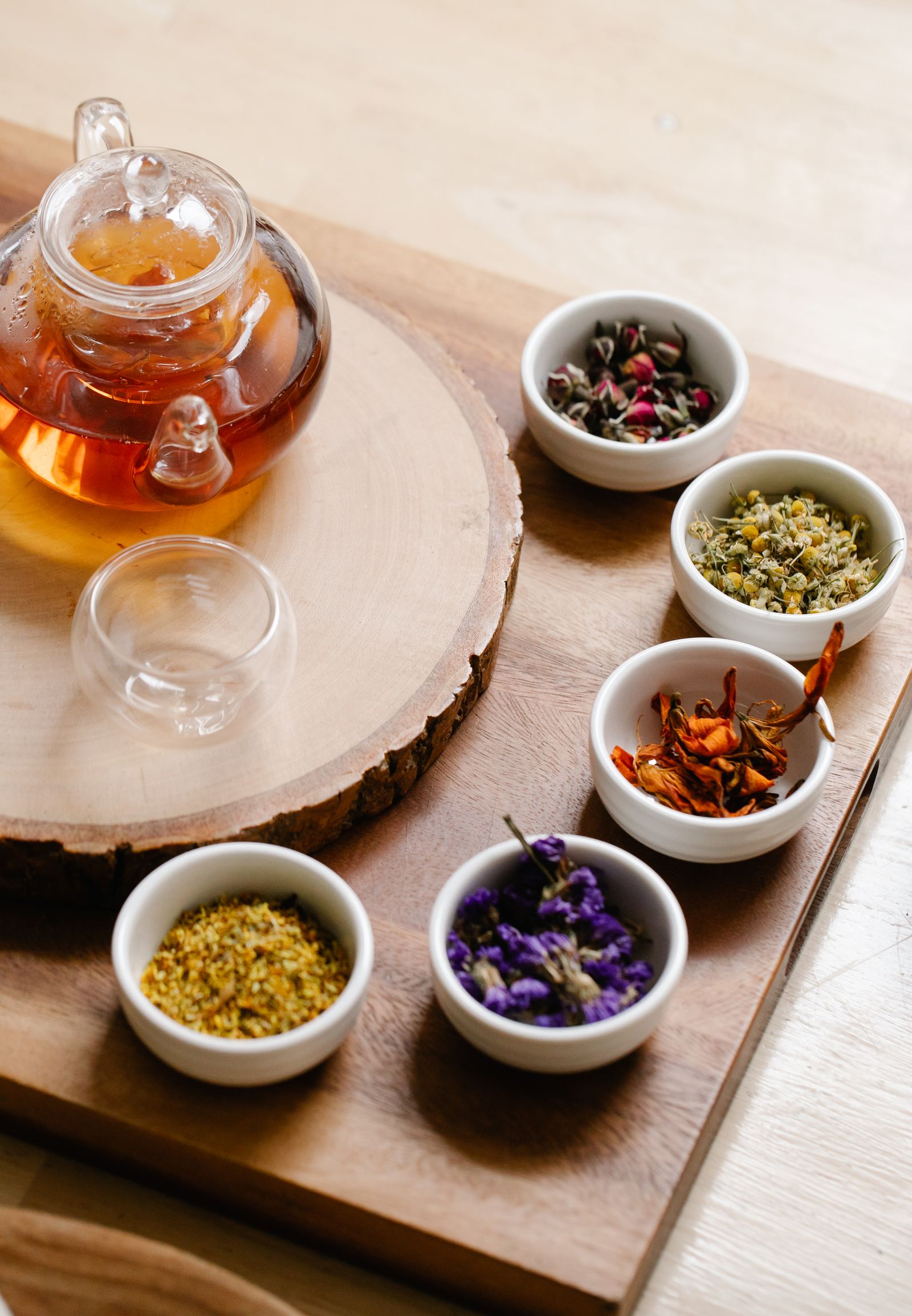 Herbal tea and dried botanicals arranged on a wooden tray