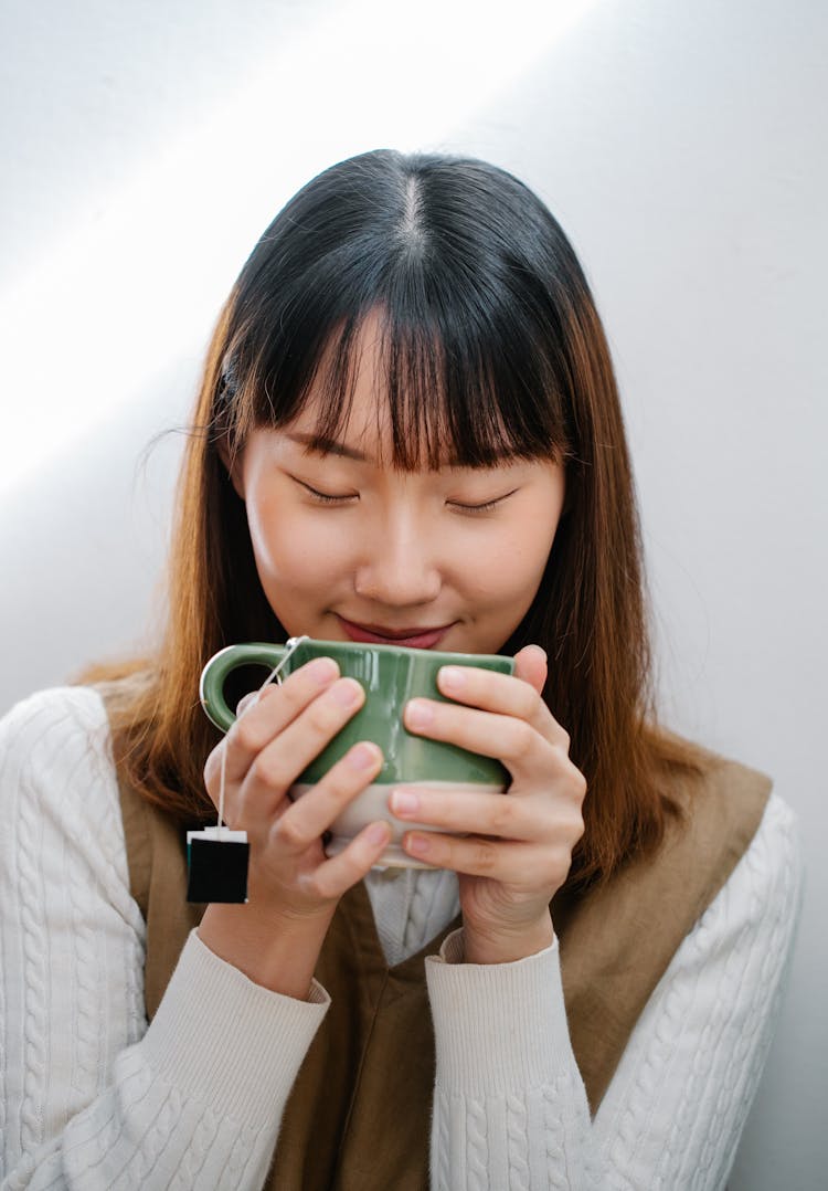 Young Woman Drinking Tea From Cup