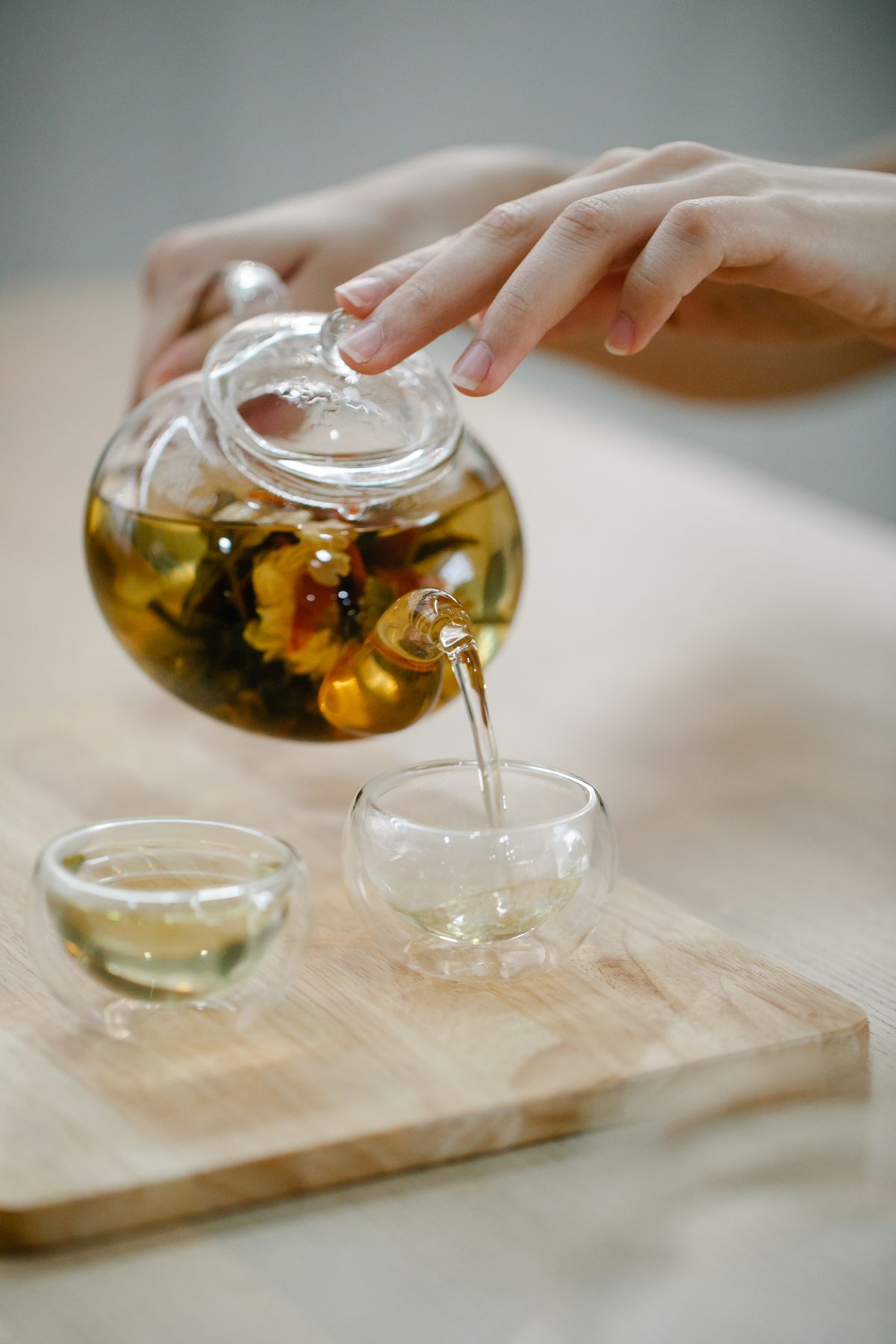 A botanical herbal drink being poured into a clear glass