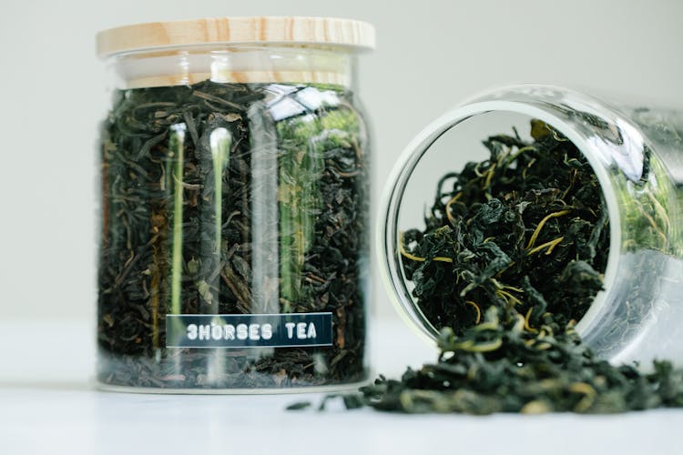 Close-up Of Green Tea Leaves In Glass Jars