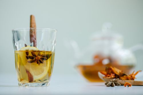 Free Elegant glass of spiced tea with lemon and star anise on a white background. Stock Photo