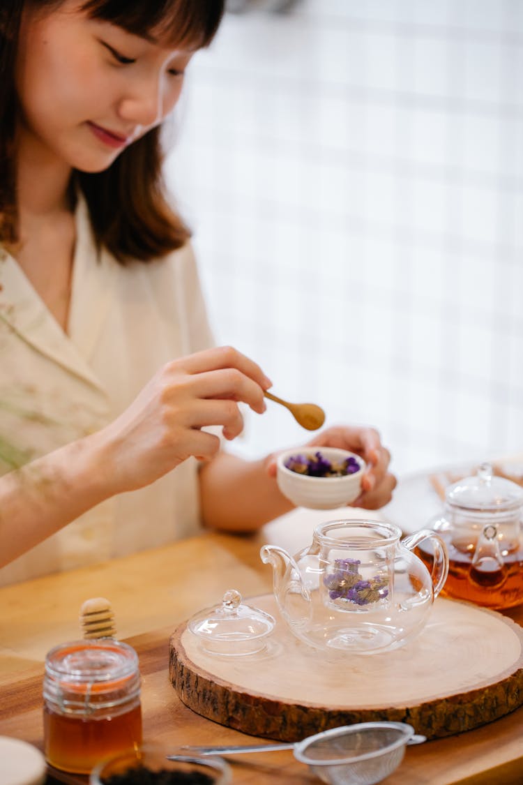 Young Woman Preparing Infusion In Teapot