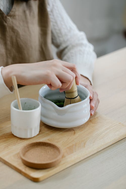 Person Holding White Ceramic Bowl With Green Powder