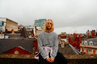 阴天里，一位沉思的年轻人在城市屋顶上休闲地待着