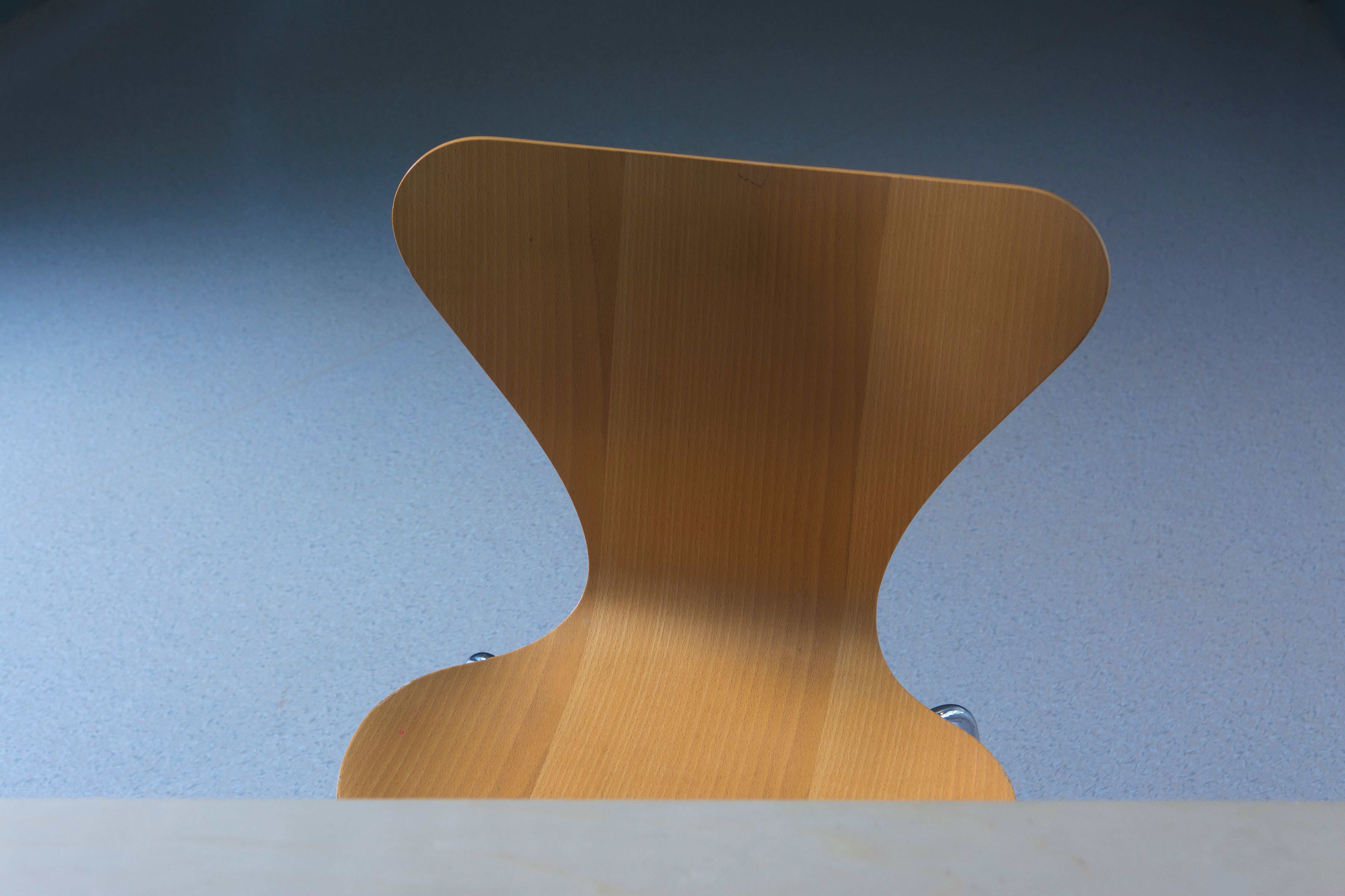 Elegant wooden chair with minimalist design in a serene setting, showcasing simplicity.