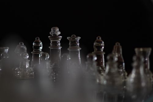 Free Intriguing close-up view of glass chess pieces against a dark background. Stock Photo