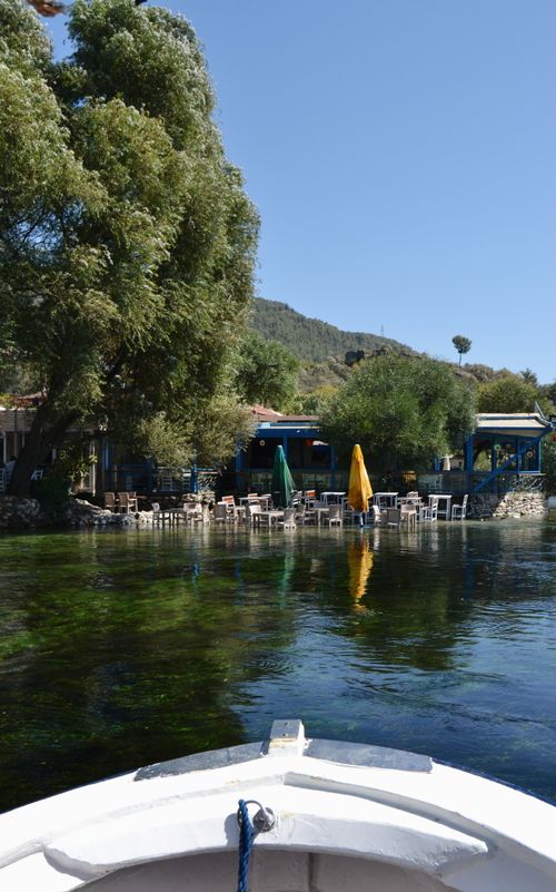 Free A serene riverside café setting in Muğla, Türkiye with vibrant umbrellas and clear skies. Stock Photo