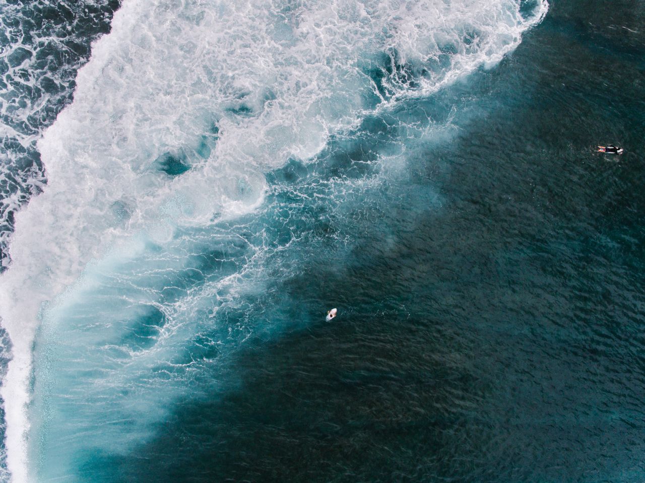 drone shot capturing surfers navigating large ocean waves embodying ad