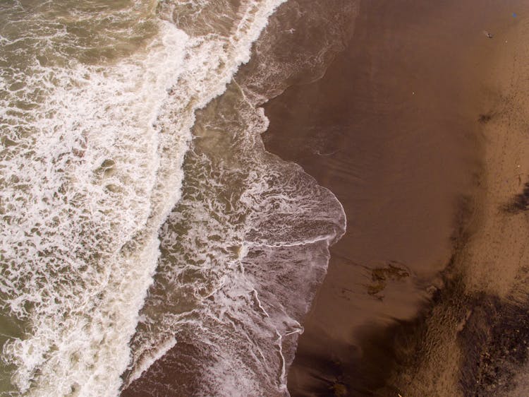 Crashing Waves On Brown Sand