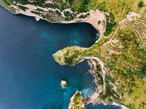 Free A breathtaking aerial shot of a tropical coastline with lush cliffs and turquoise waters. Stock Photo