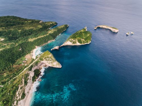 Free A breathtaking aerial view of green rock formations by the sea. Stock Photo