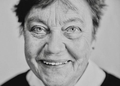 Grayscale Photo of an Elderly Woman Smiling