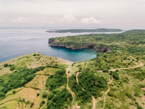 Free Breathtaking aerial view of a lush coastline with cliffs and a serene bay. Stock Photo