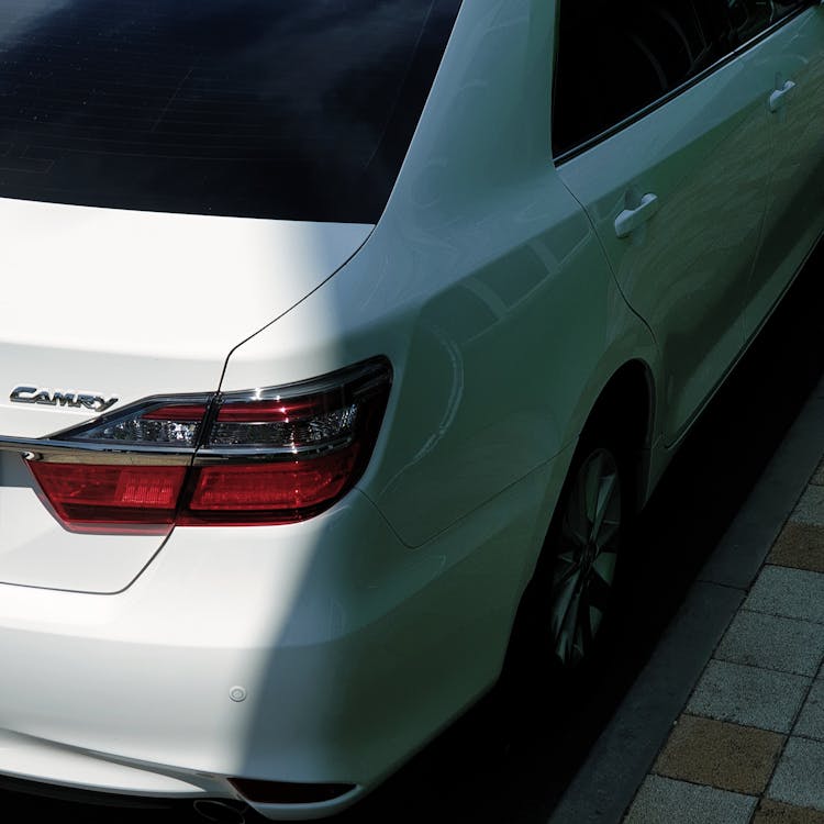 A White Car Parked Near A Curb