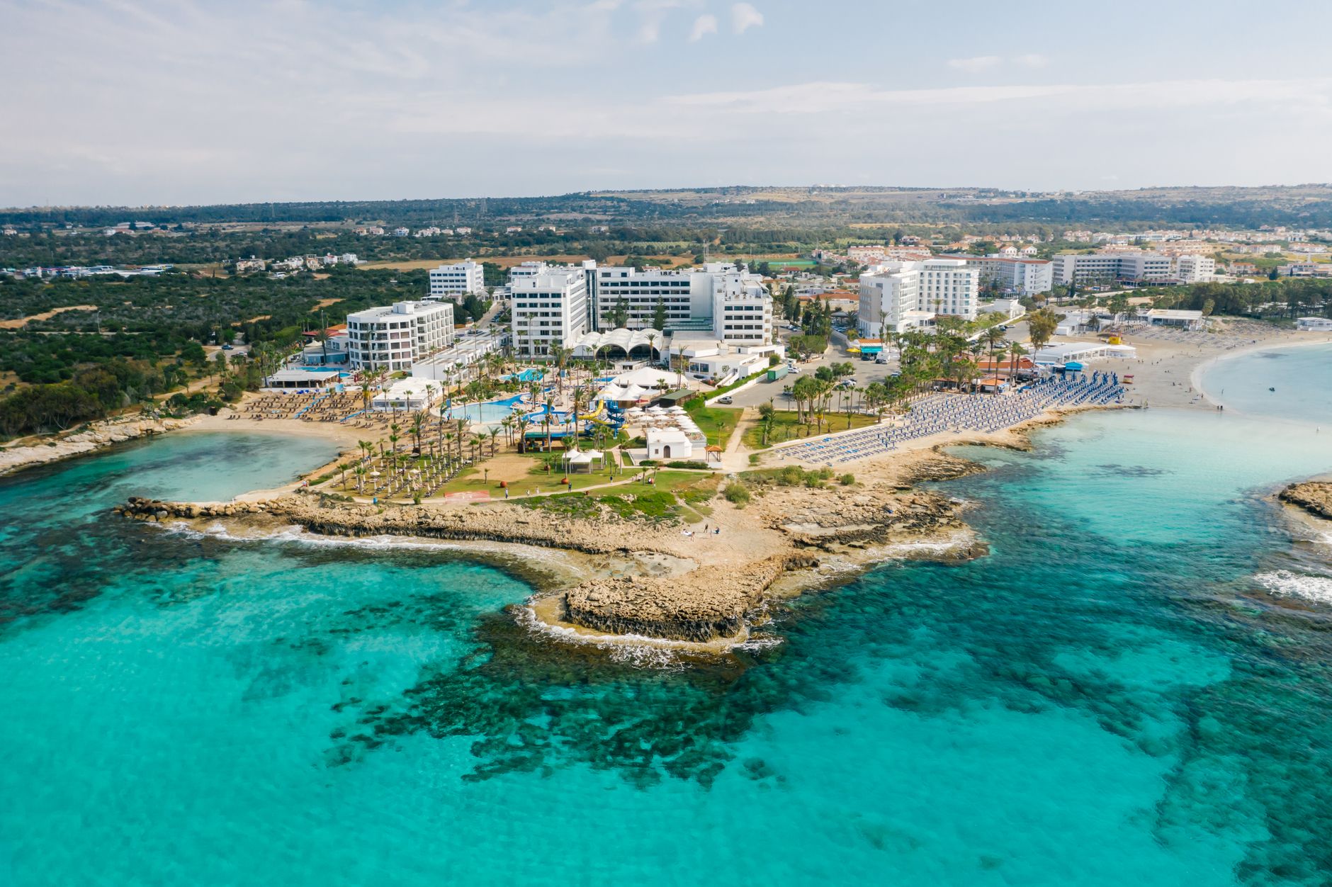Aerial view of a Cyprus seaside resort with clear water and hotels