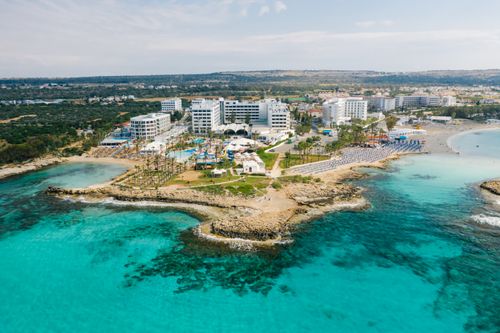 Free Stunning aerial shot of a Cyprus seaside resort showcasing crystal clear waters and luxury hotels. Stock Photo