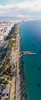 A stunning aerial view of a coastal city with a scenic promenade along the oceanfront.