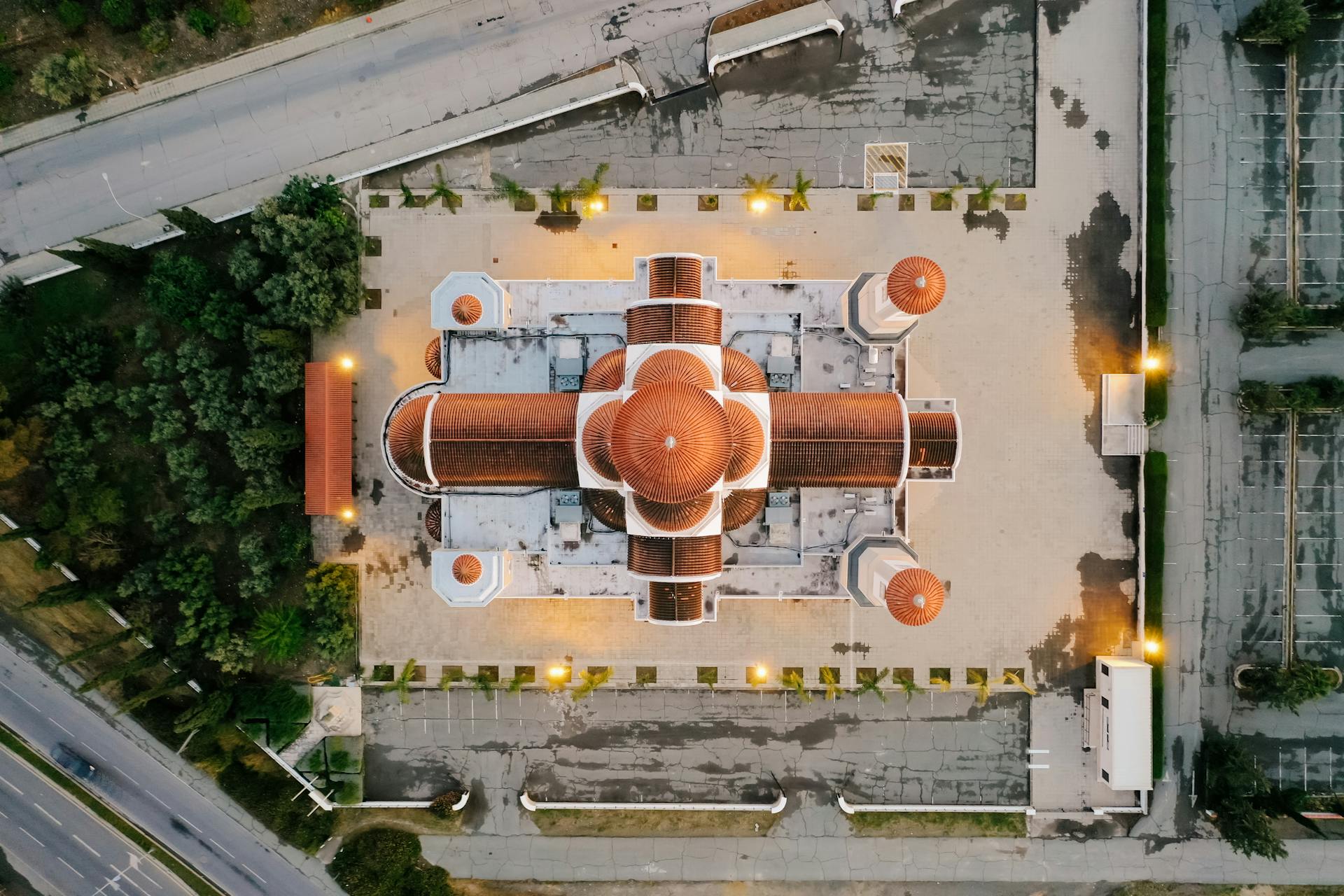 Drone shot capturing a top view of a domed architectural structure, glowing lights accentuating the design.