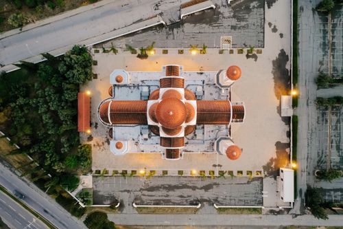 Free Drone shot capturing a top view of a domed architectural structure, glowing lights accentuating the design. Stock Photo