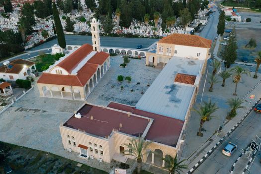 Stunning aerial view of a church with red roof in an urban setting surrounded by greenery.