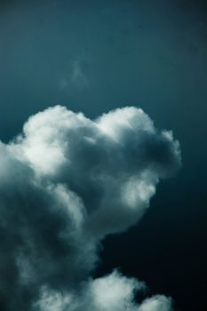 A striking cumulus cloud set against a deep, moody sky, showcasing nature's drama.