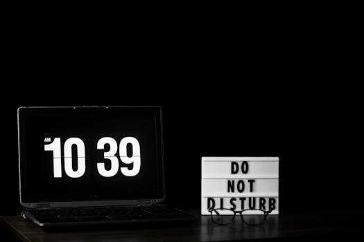 A laptop showing time with a 'Do Not Disturb' sign, perfect for productivity themes.